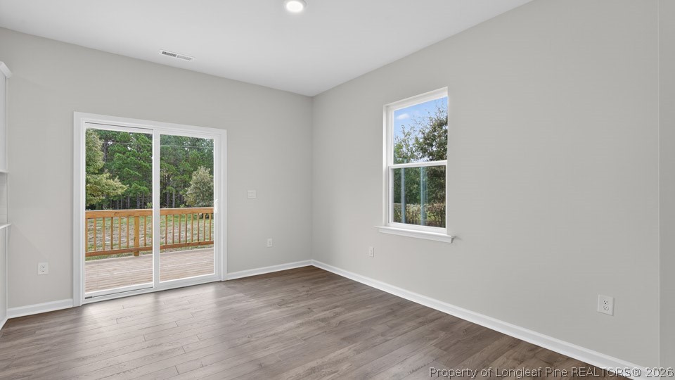 194 Fair Child Road Spring Lake, NC 28390 - Photo 10 of 33 an empty room with wooden floor and windows