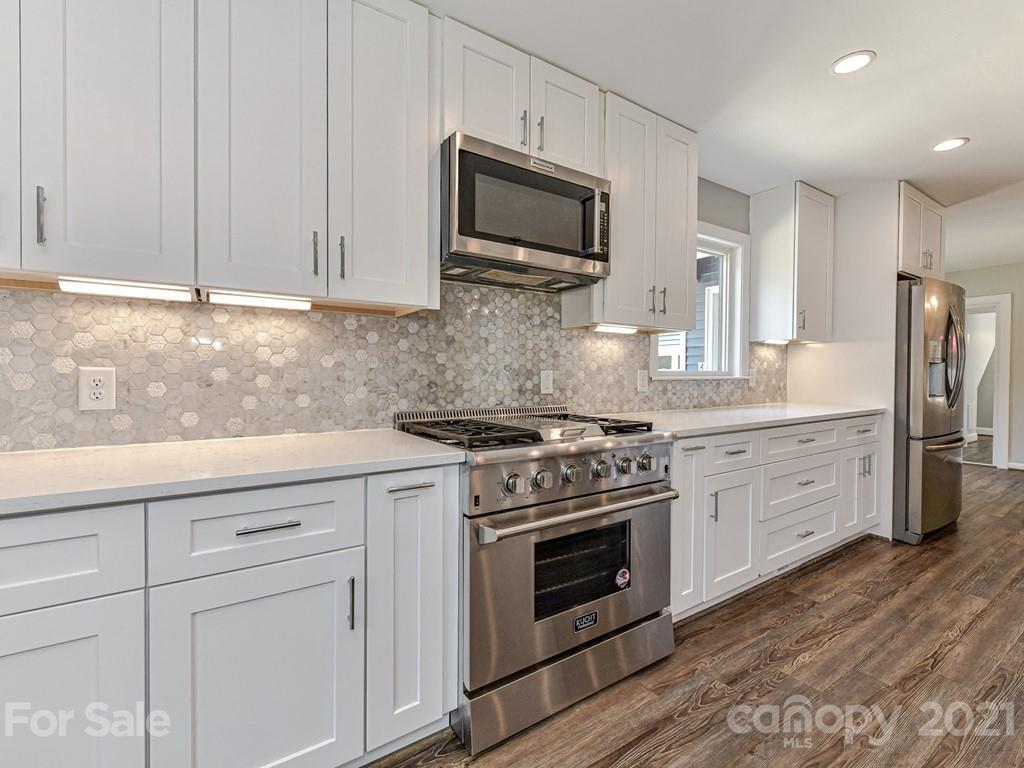 305 Boyce Road Charlotte, NC 28211 - Photo 11 of 48 a kitchen with granite countertop white cabinets stainless steel appliances and sink