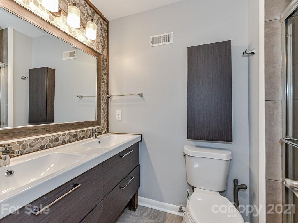305 Boyce Road Charlotte, NC 28211 - Photo 27 of 48 a bathroom with a sink a toilet a mirror and shower
