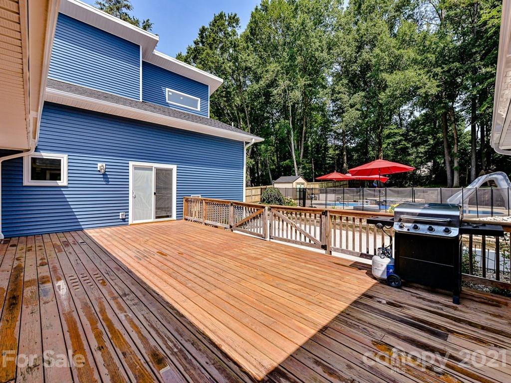 305 Boyce Road Charlotte, NC 28211 - Photo 32 of 48 a view of a roof deck with table and chairs under an umbrella with wooden floor and fence