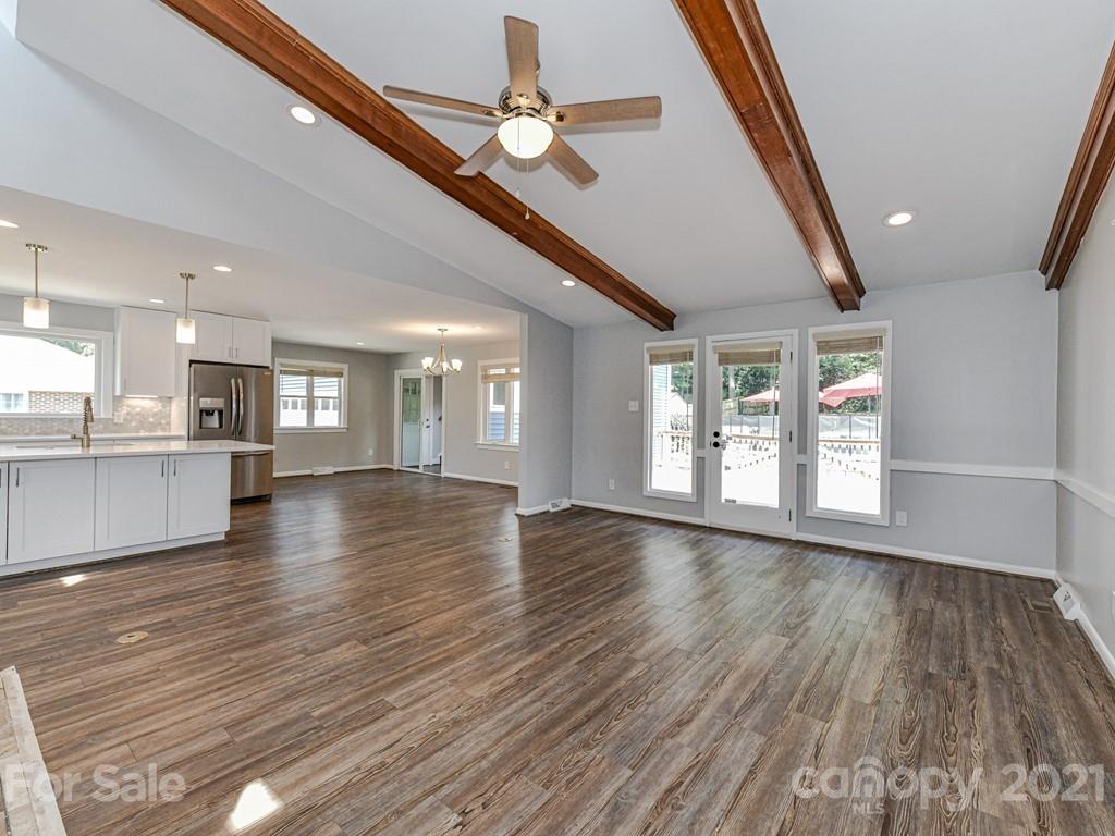 305 Boyce Road Charlotte, NC 28211 - Photo 8 of 48 a view of an empty room with wooden floor and a kitchen