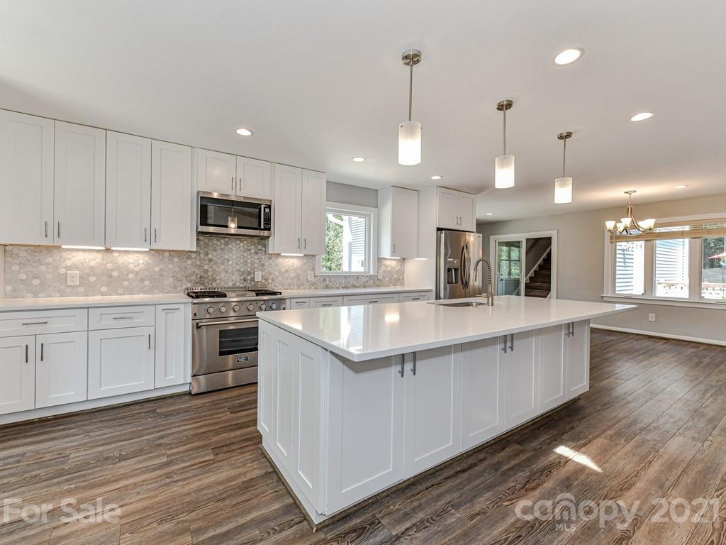 305 Boyce Road Charlotte, NC 28211 - Photo 10 of 48 a large kitchen with stainless steel appliances granite countertop a sink a stove and a wooden floors