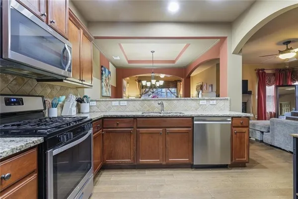 a kitchen with stainless steel appliances granite countertop a refrigerator stove and sink