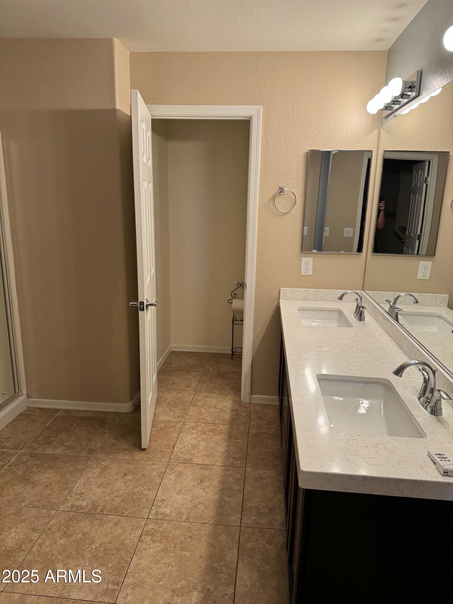 11009 East Sutter Avenue Mesa, AZ 85212 - Photo 20 of 32 a bathroom with a sink a mirror and a shower