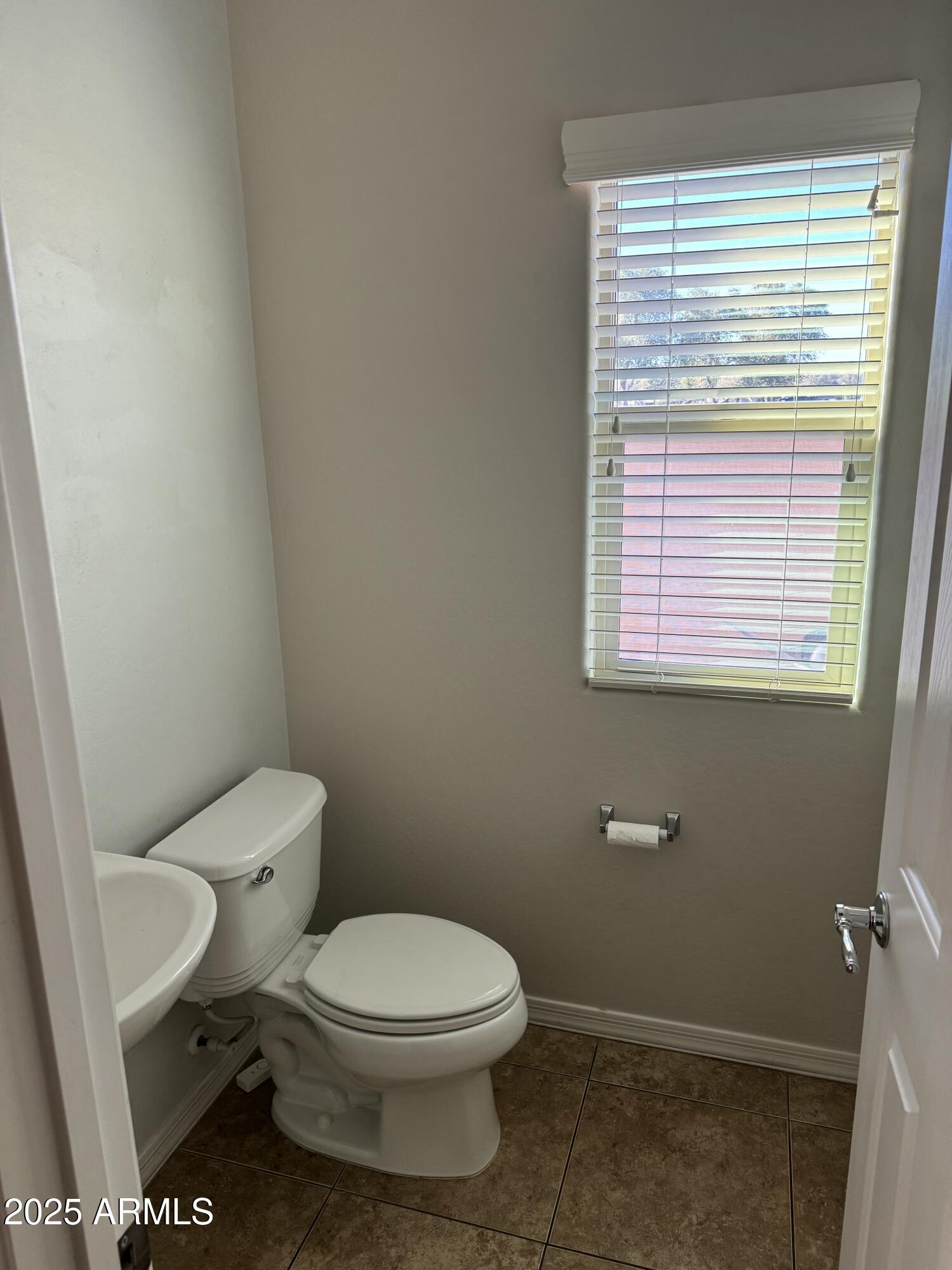 11009 East Sutter Avenue Mesa, AZ 85212 - Photo 8 of 32 a white toilet sitting in a bathroom next to a window