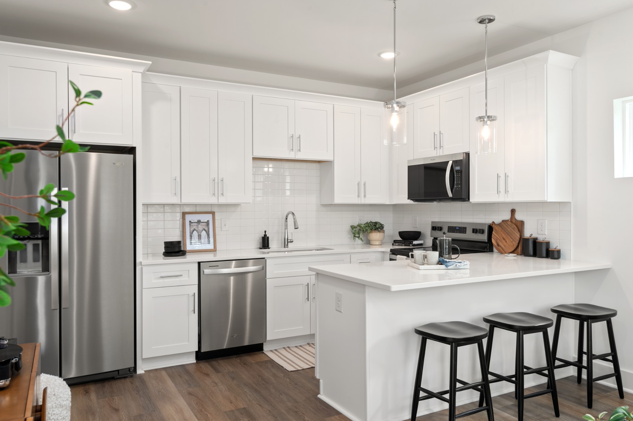 a kitchen with stainless steel appliances a sink a stove a refrigerator cabinets and a window