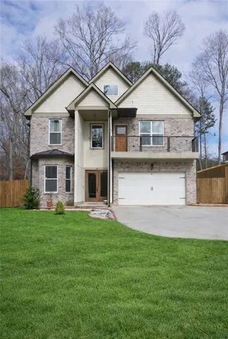 a front view of a house with a yard and garage