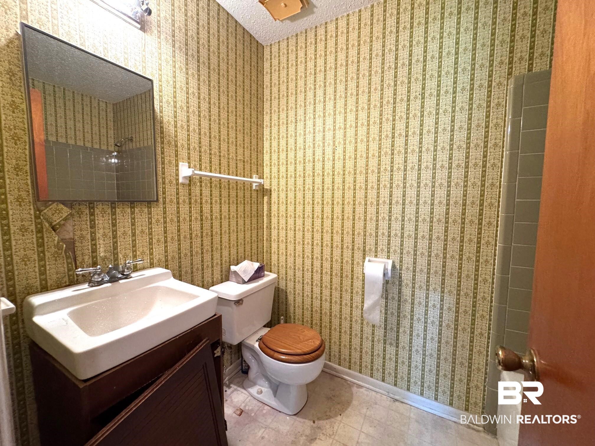 5198 Lancelot Drive Mobile, AL 36619 - Photo 12 of 30 Full bath featuring vanity, wallpapered walls, bathing tub / shower combination, and a textured ceiling