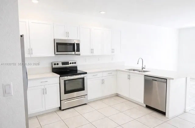 a kitchen with white cabinets and stainless steel appliances