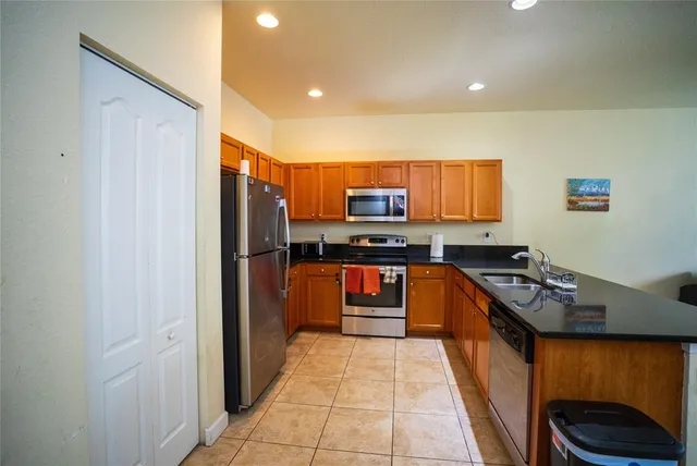a kitchen with stainless steel appliances granite countertop a stove a sink and a refrigerator