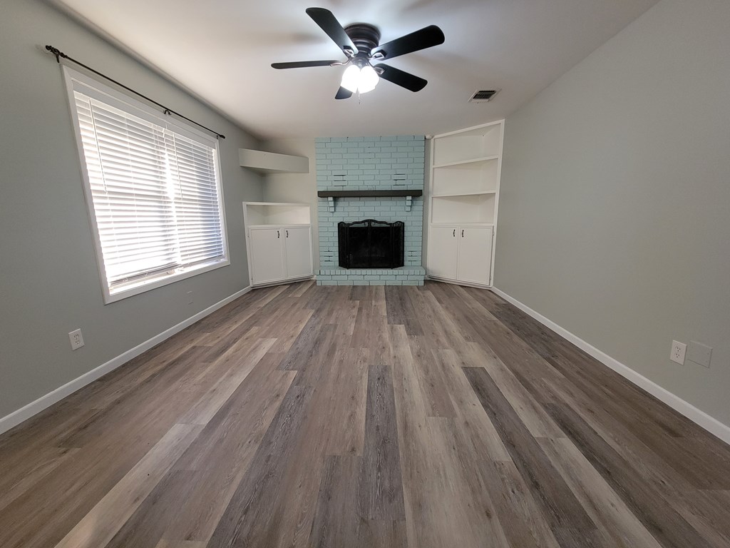 109 7th Street Ingram, TX 78025 - Photo 2 of 15 a view of an empty room with a fireplace and a window