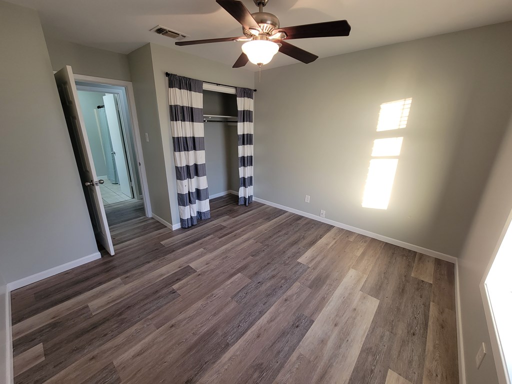 109 7th Street Ingram, TX 78025 - Photo 5 of 15 wooden floor in an empty room with a window