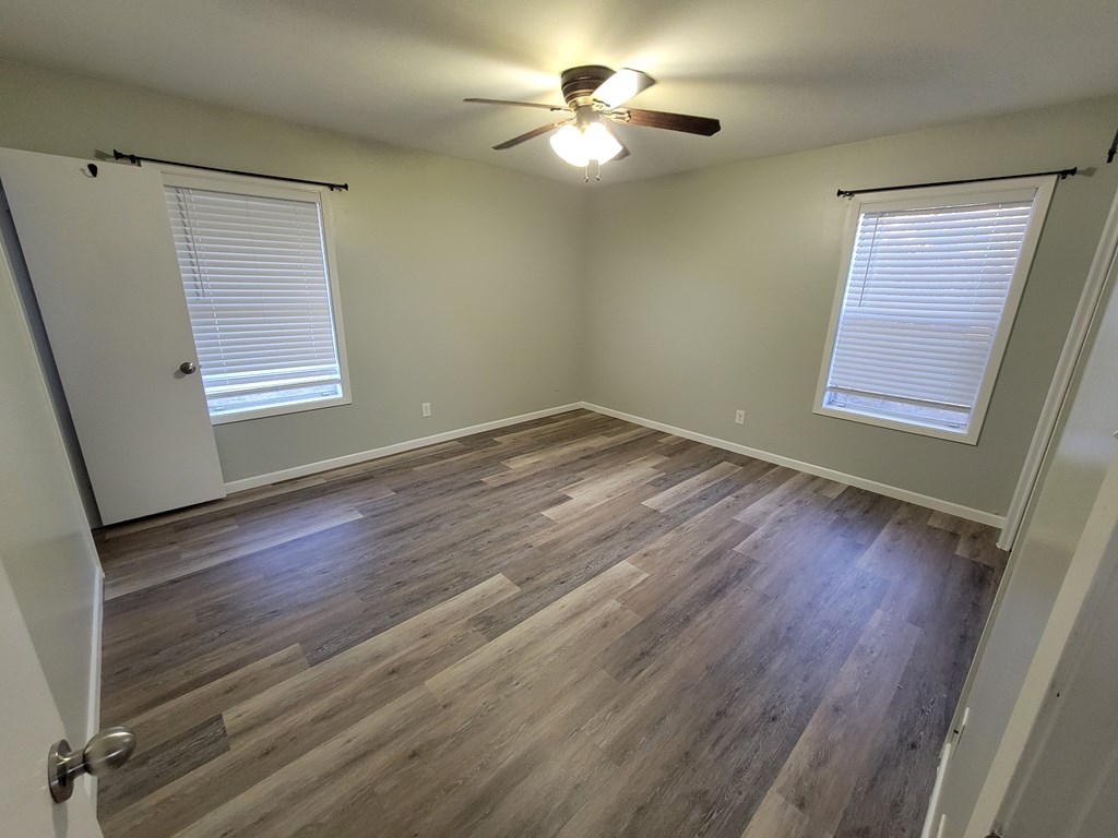 109 7th Street Ingram, TX 78025 - Photo 8 of 15 a view of an empty room with a window and wooden floor