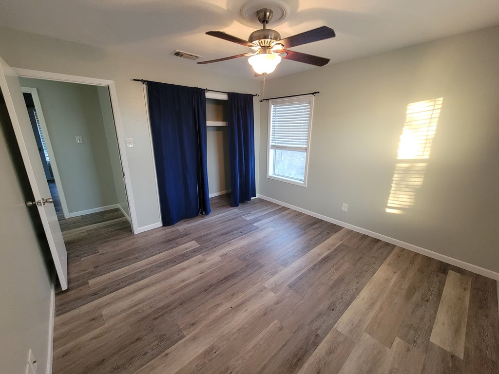 109 7th Street Ingram, TX 78025 - Photo 9 of 15 wooden floor in an empty room with a window