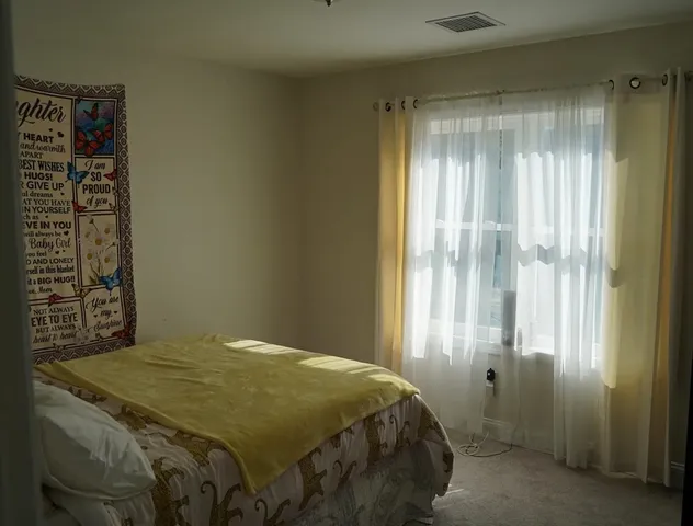 a bedroom with a bed and a window