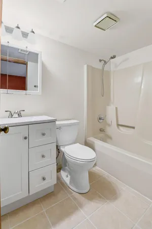 a bathroom with a toilet sink vanity and bathtub
