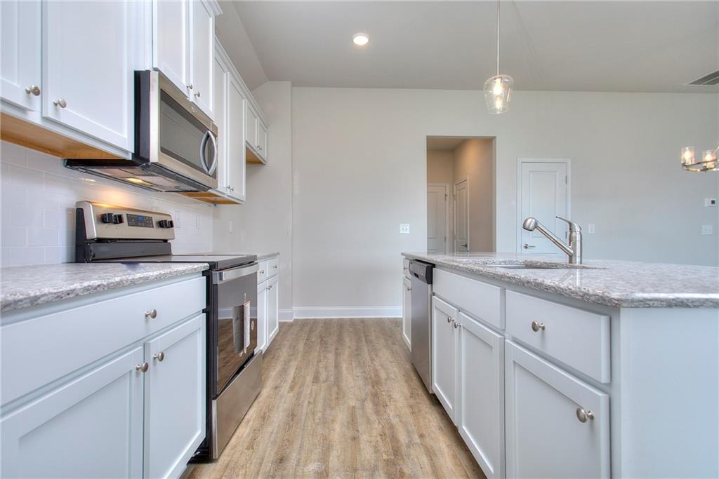 139 Swallowtail Lane Homer, GA 30547 - Photo 12 of 33 a kitchen with stainless steel appliances granite countertop a sink and dishwasher a stove top oven with wooden floor