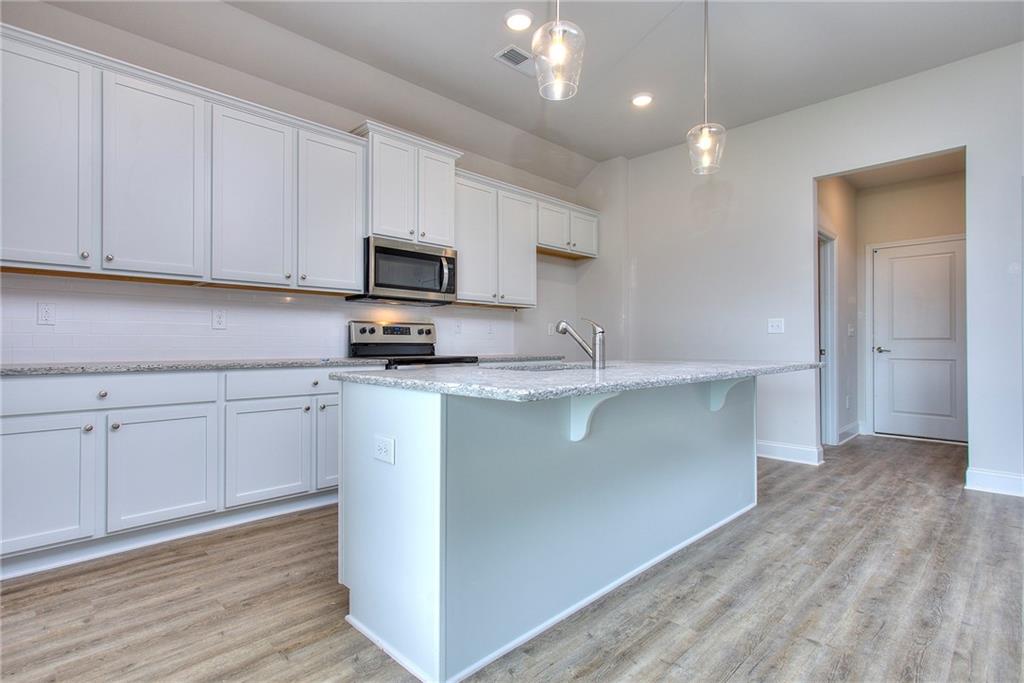 139 Swallowtail Lane Homer, GA 30547 - Photo 13 of 33 a kitchen with kitchen island white cabinets appliances and a sink