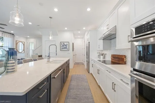 a large kitchen with stainless steel appliances lots of counter space and wooden floor