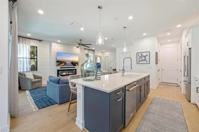 a kitchen with kitchen island a sink and a refrigerator