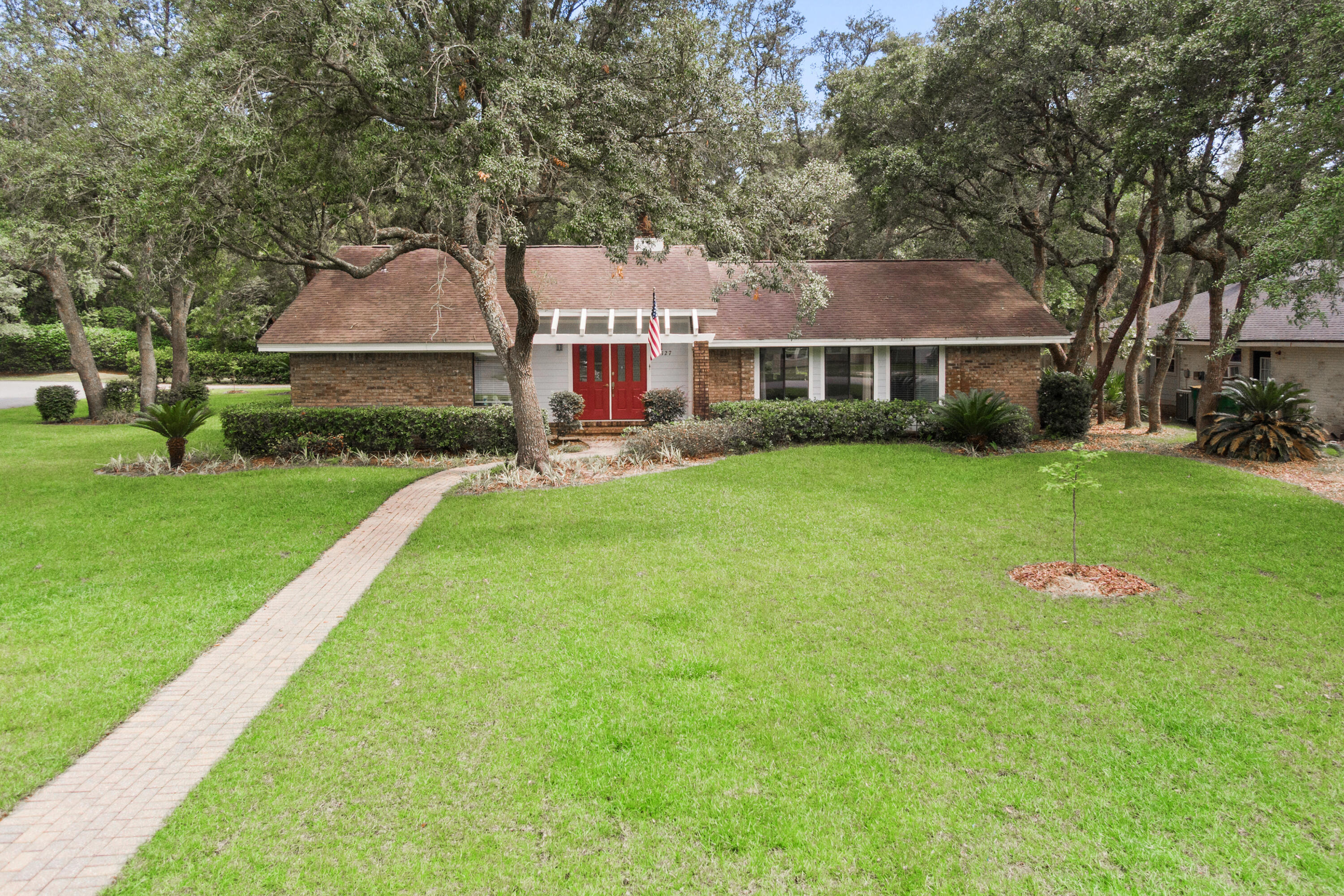 a front view of a house with a yard and trees