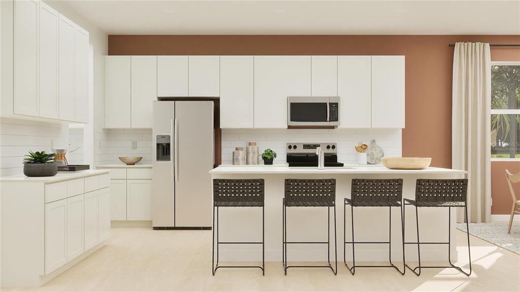 5653 Banyan Bay Road St. Cloud, FL 34771 - Photo 2 of 29 a kitchen with stainless steel appliances a stove a sink cabinets and a refrigerator