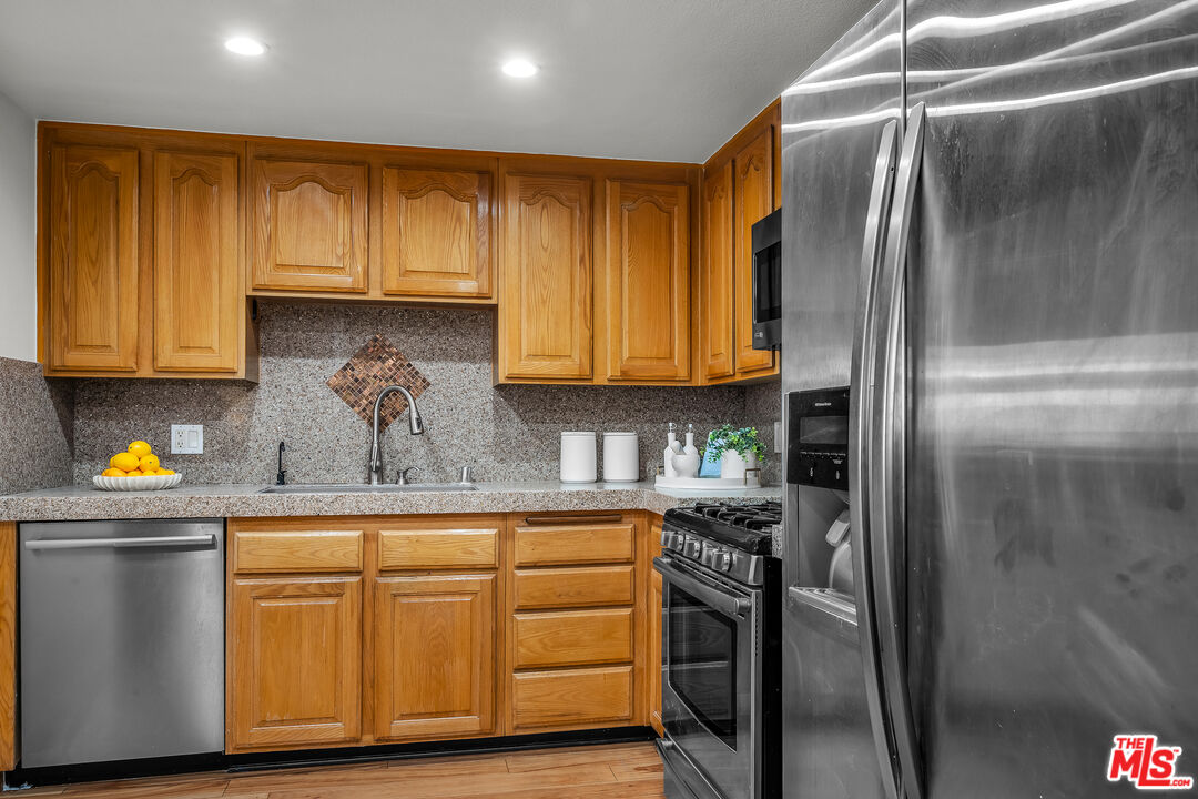 8162 Manitoba Street, Unit 202 Playa del Rey, CA 90293 - Photo 20 of 34 a kitchen with stainless steel appliances granite countertop a refrigerator and cabinets