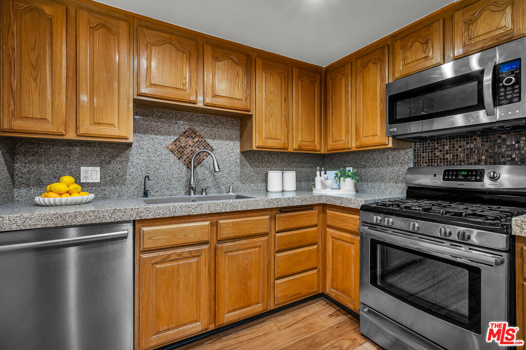 8162 Manitoba Street, Unit 202 Playa del Rey, CA 90293 - Photo 21 of 34 a kitchen with stainless steel appliances granite countertop a stove a sink and a microwave