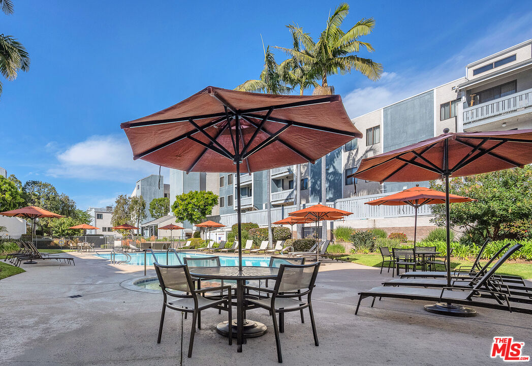 8162 Manitoba Street, Unit 202 Playa del Rey, CA 90293 - Photo 26 of 34 a view of an outdoor space with a table and chairs under an umbrella