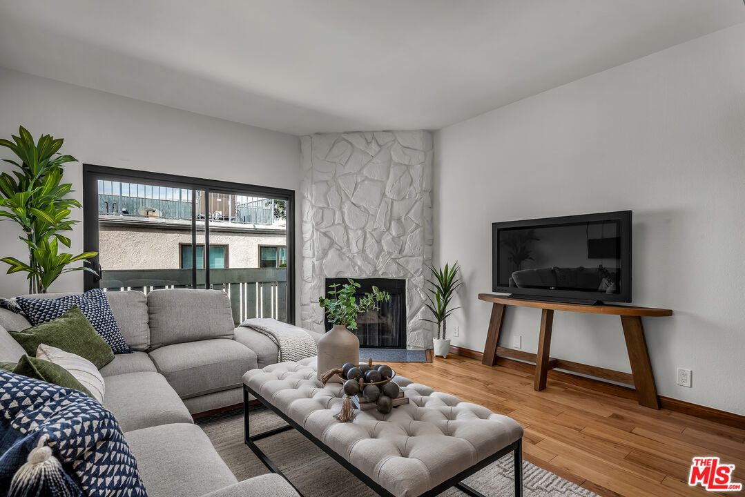 8162 Manitoba Street, Unit 202 Playa del Rey, CA 90293 - Photo 4 of 34 a living room with furniture a flat screen tv and a fireplace