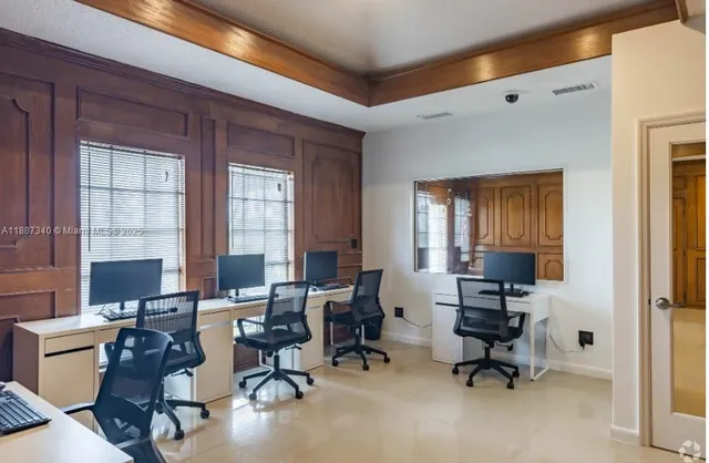 an aerial view of a residential houses with outdoor space and trees