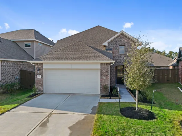 a view of a house with a yard and potted plants