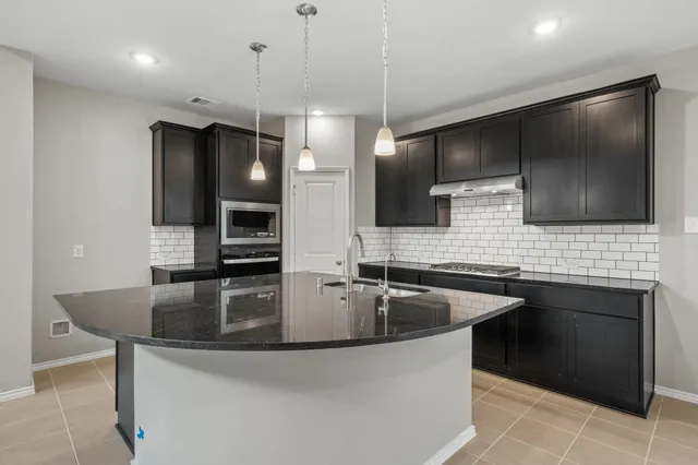 a kitchen with stainless steel appliances granite countertop a sink and a microwave