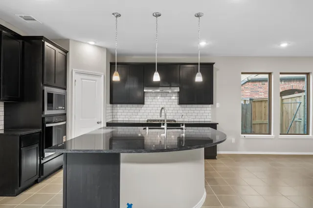 a kitchen with stainless steel appliances granite countertop a sink refrigerator and cabinets