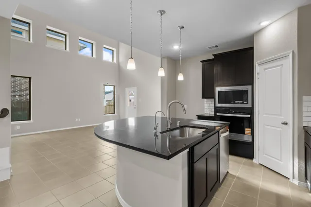 a kitchen with stainless steel appliances granite countertop a sink a stove and a refrigerator