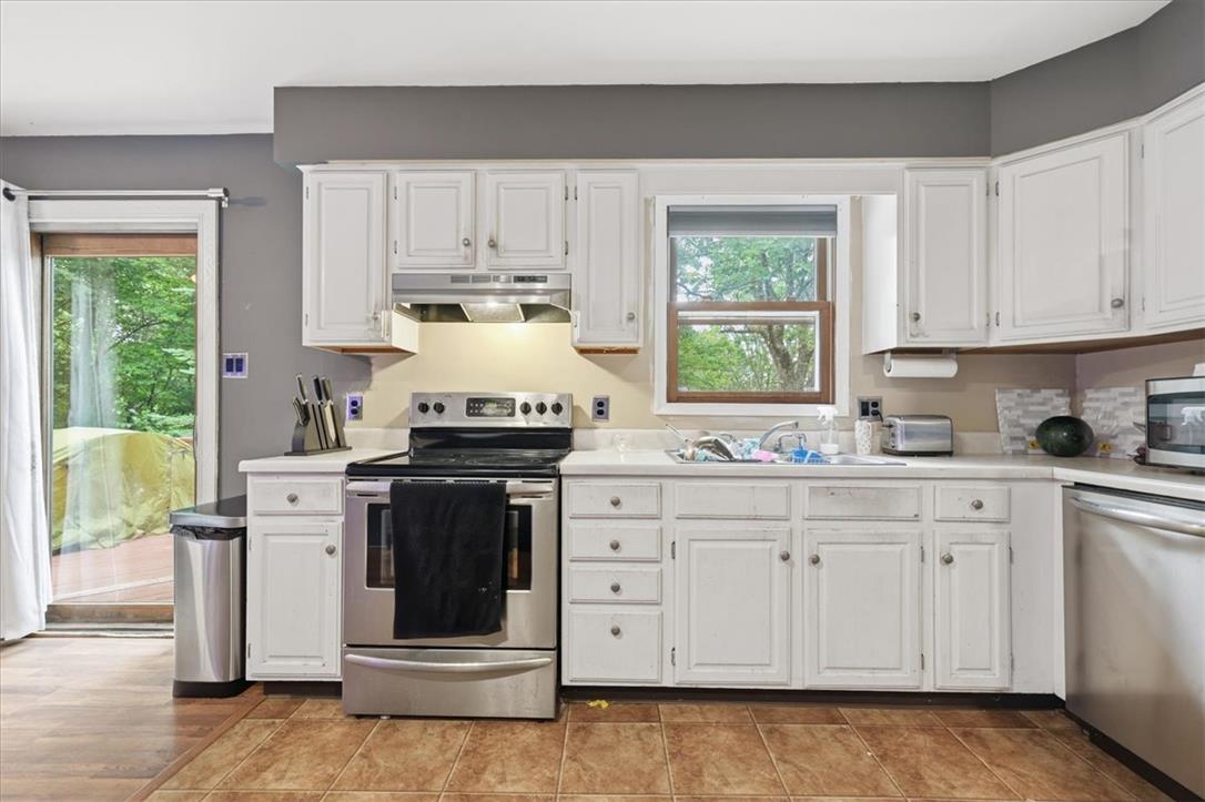520 Highland Hill Road Jim Thorpe, PA 18235 - Photo 14 of 83 A well-equipped kitchen features crisp white cabinetry and durable tile flooring, with direct access to the outdoors.