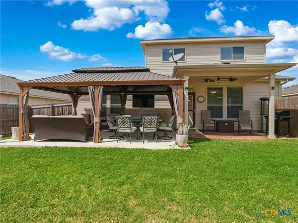 a view of a house with backyard porch and sitting area
