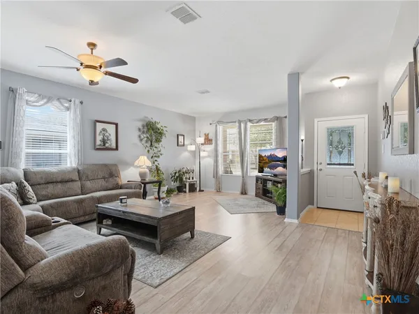 a living room with furniture a ceiling fan and a window