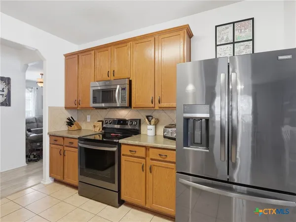 a kitchen with stainless steel appliances a refrigerator stove and microwave