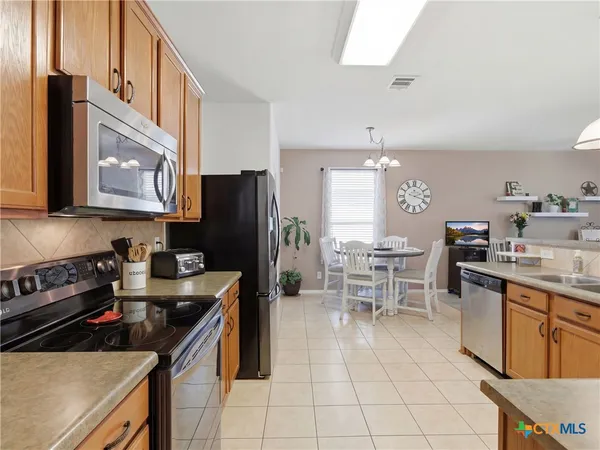 a kitchen with stainless steel appliances a stove a sink a microwave and a refrigerator