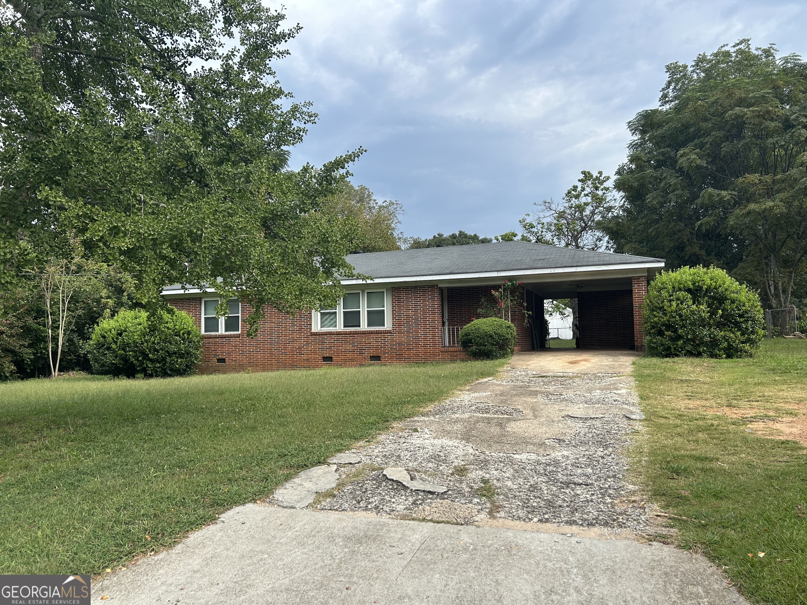 a front view of a house with a yard and trees