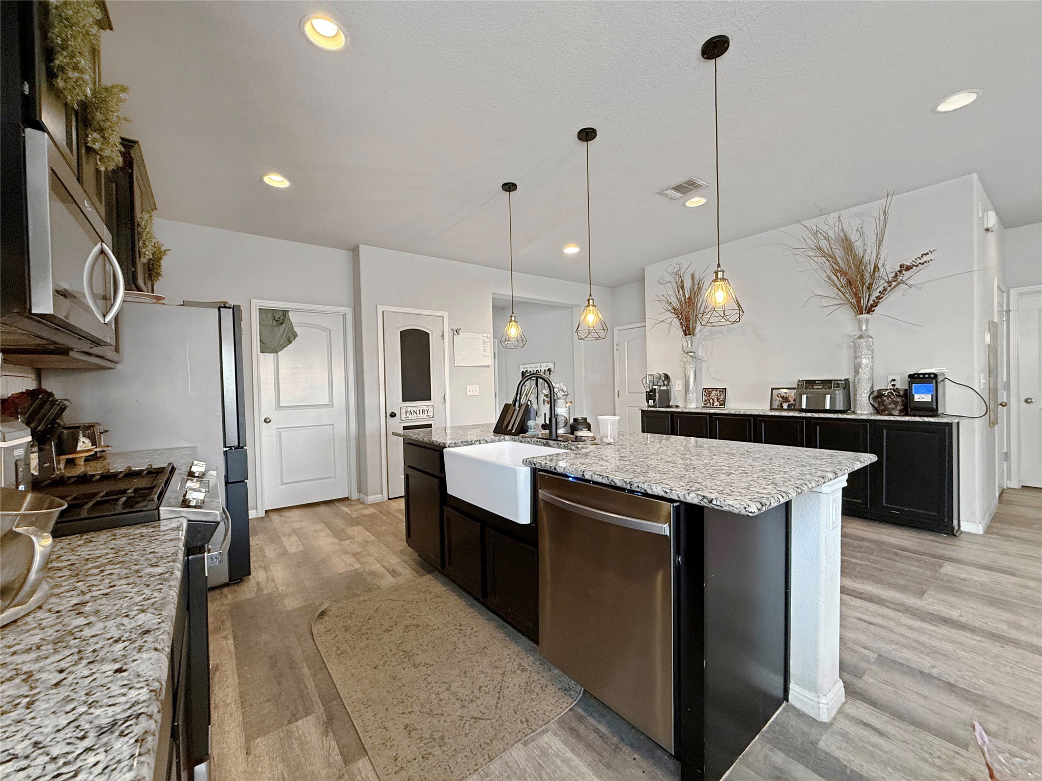 429 Rusk Bluff Avenue Leander, TX 78641 - Photo 4 of 24 A well-appointed kitchen showcasing a central island, granite countertops, and modern stainless steel appliances.