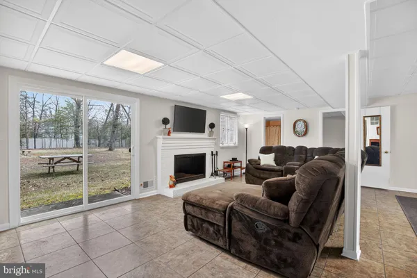 a living room with furniture a fireplace and a floor to ceiling window