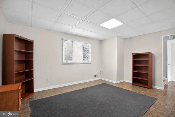 a view of an empty room with cabinet and a window