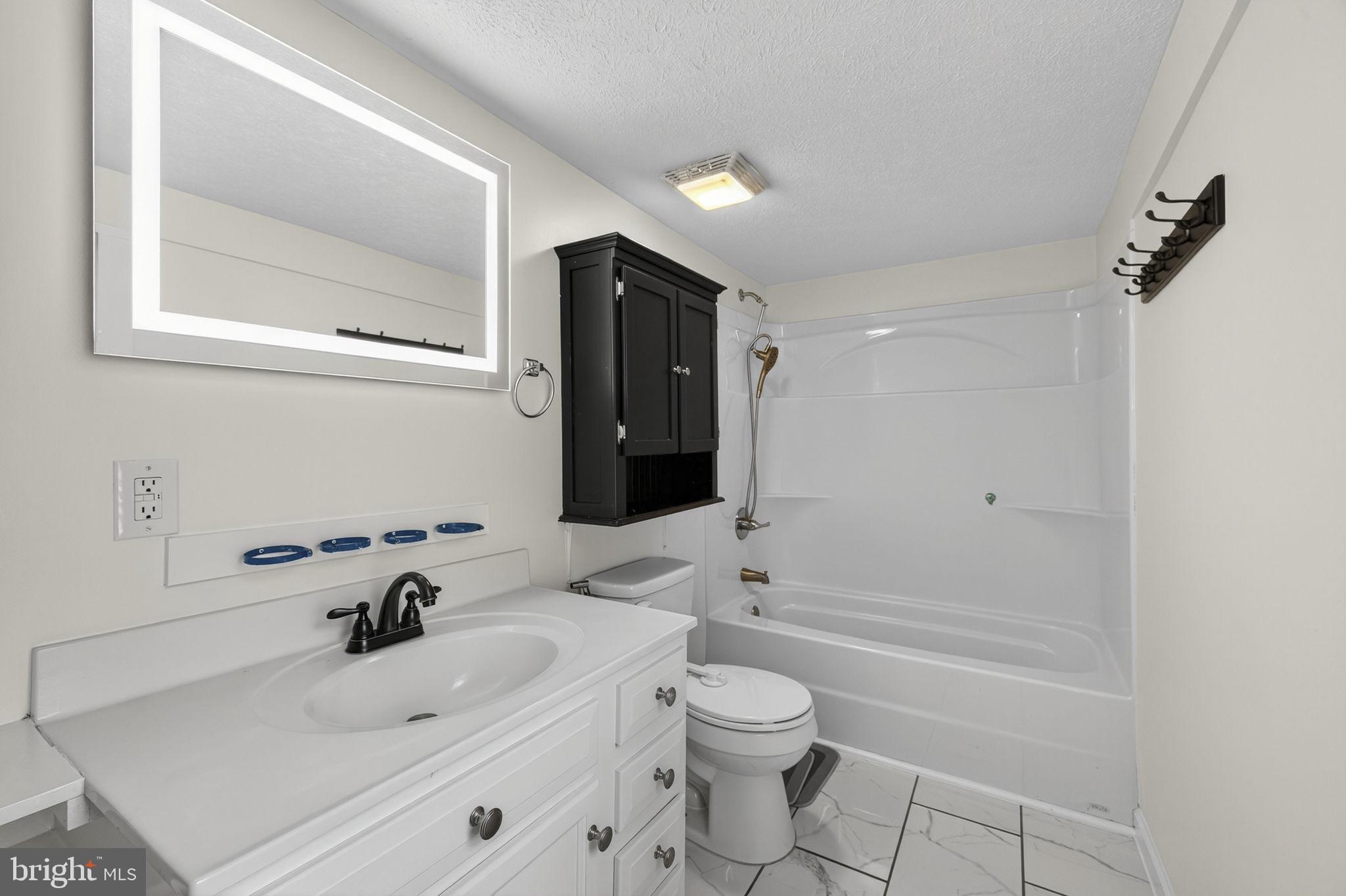 239 McDonald Road Winchester, VA 22602 - Photo 10 of 20 a bathroom with a sink a toilet and shower