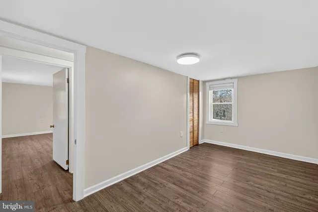 a view of a room with wooden floor and white walls