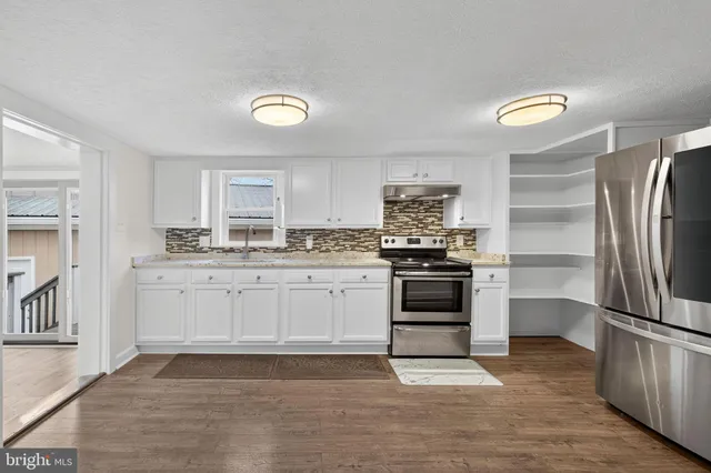 a kitchen with a refrigerator and a stove top oven