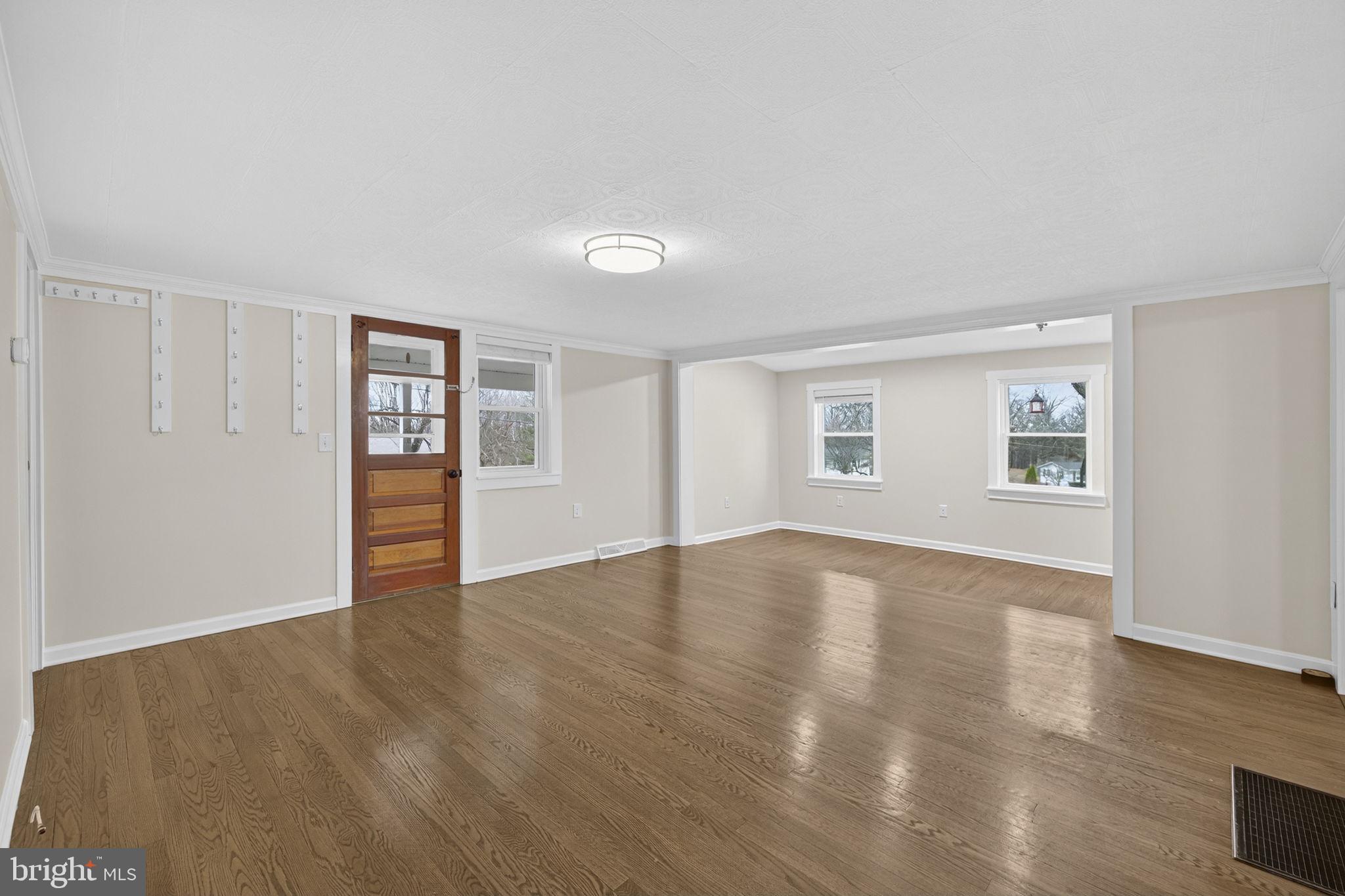 239 McDonald Road Winchester, VA 22602 - Photo 5 of 20 a view of an empty room with wooden floor and a window