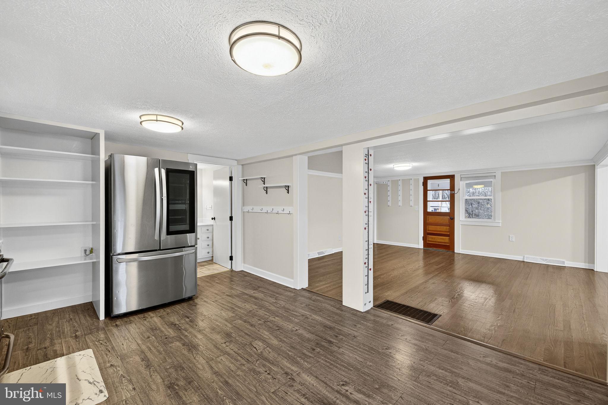 239 McDonald Road Winchester, VA 22602 - Photo 20 of 20 an empty room with wooden floor and kitchen
