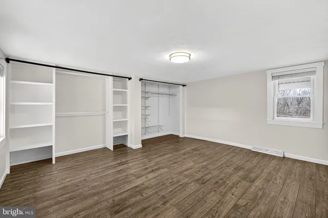 a view of an empty room with wooden floor